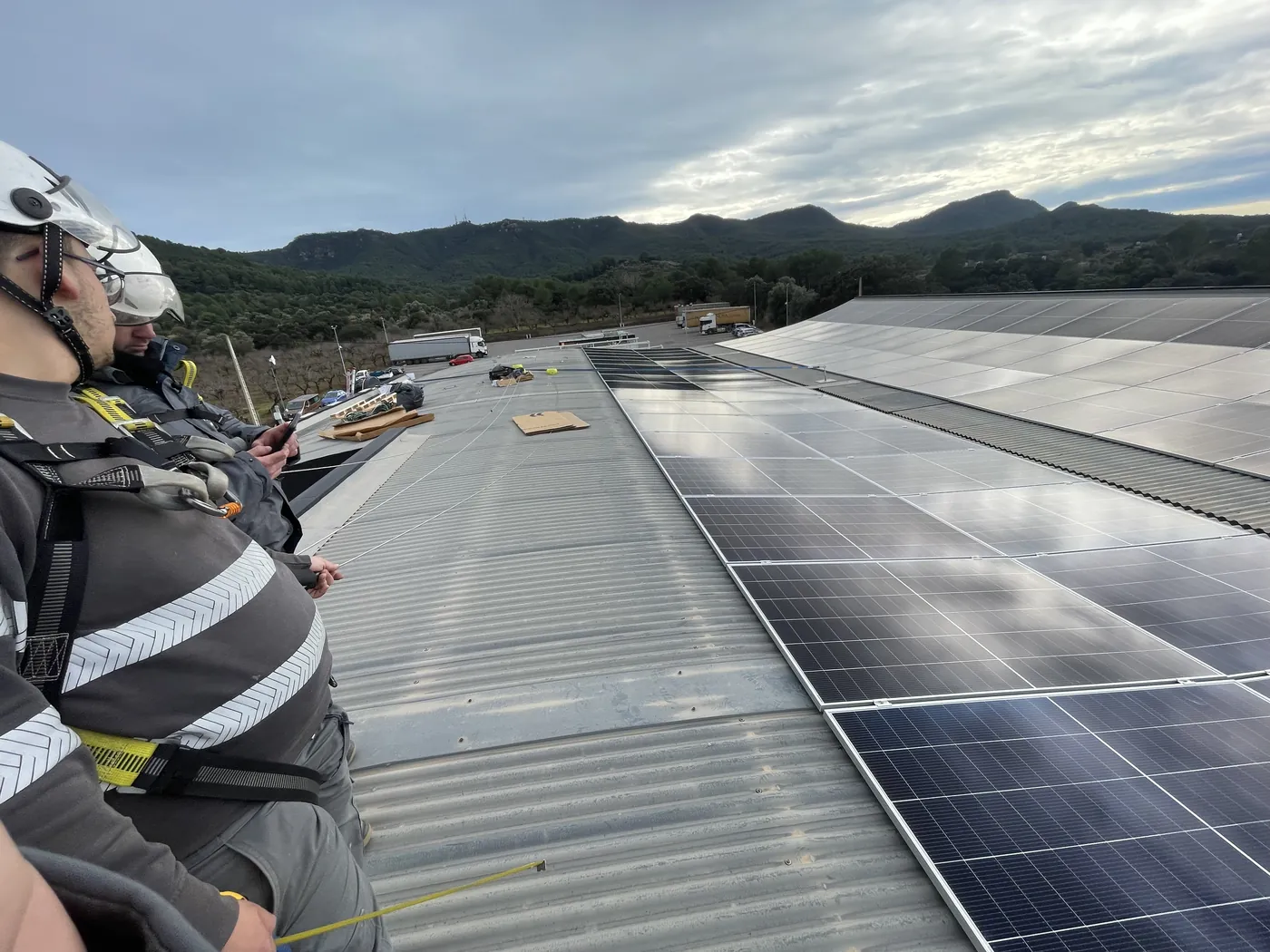 Operarios de Fritts con arnés y línea de vida trabajando sobre una cubierta fotovoltaica