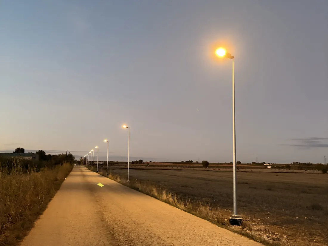 Camino con farolas LED encendidas al anochecer
