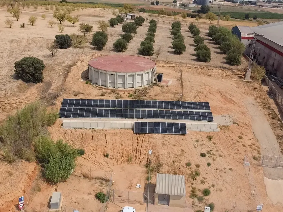 Campo fotovoltaico junto a un depósito de agua para bombeo solar