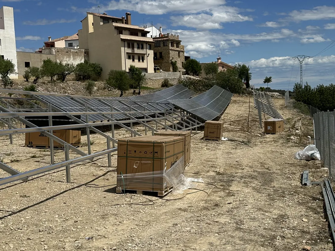 Estructura fija en montaje y palés de módulos en un huerto solar de Castellón