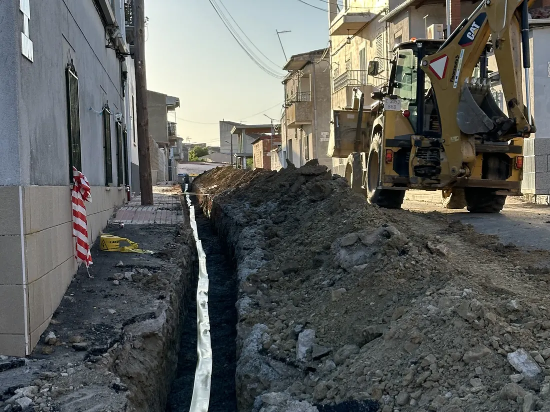 Apertura de zanja en una calle con retroexcavadora para una acometida