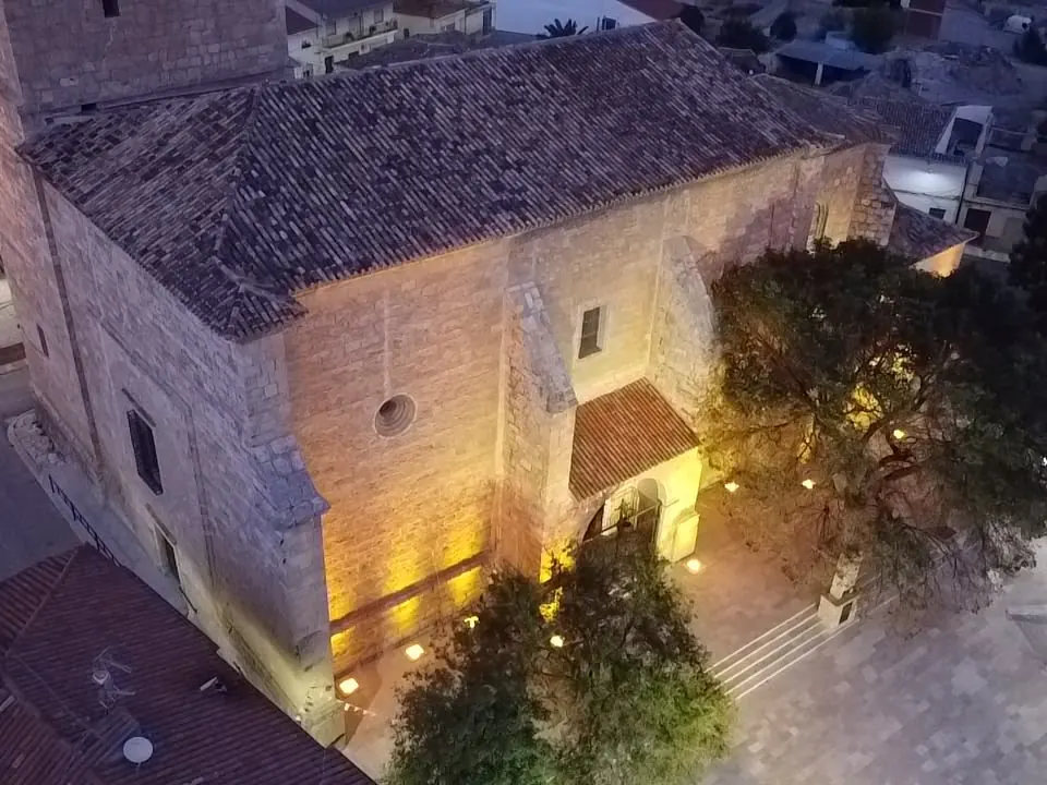 Fachada de iglesia de piedra con iluminación ornamental