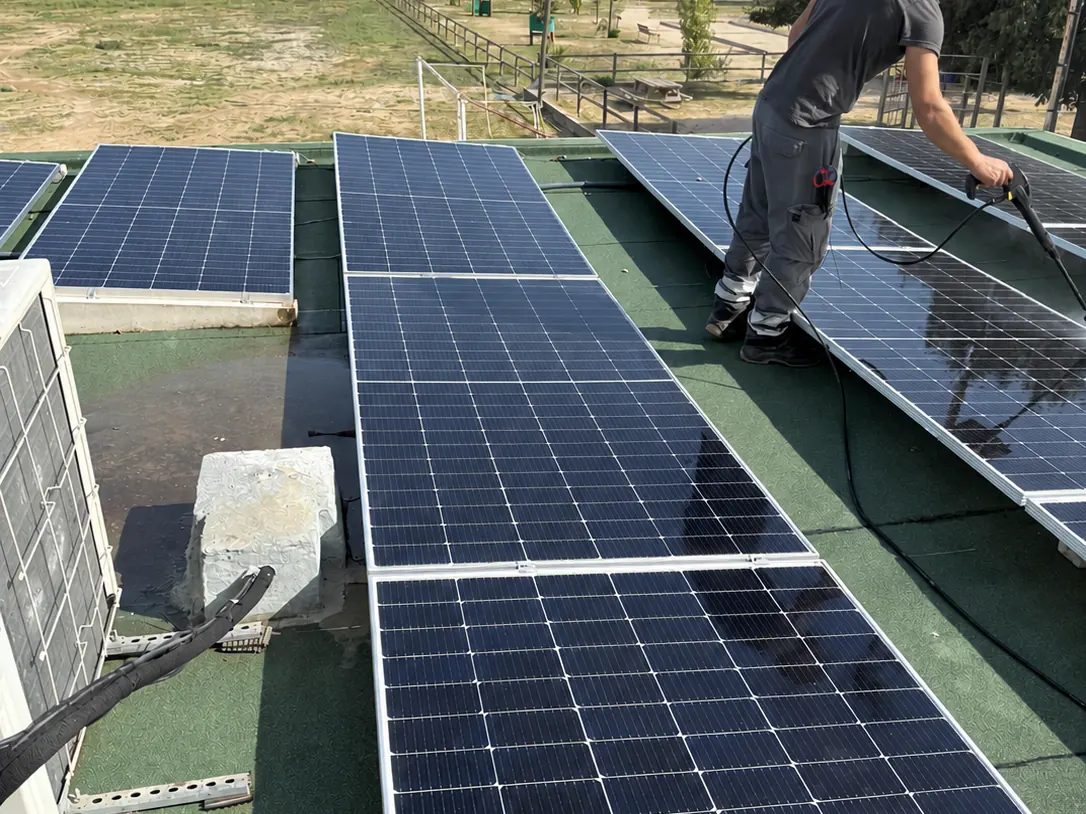 Operario de Fritts limpiando módulos fotovoltaicos con agua a presión