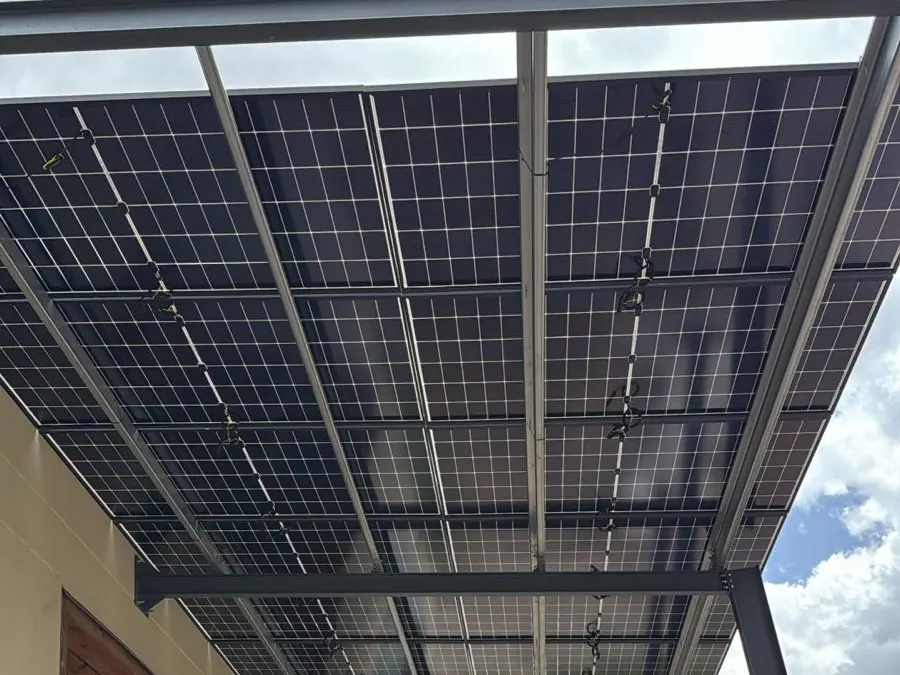 Vista inferior de una marquesina fotovoltaica con módulos bifaciales