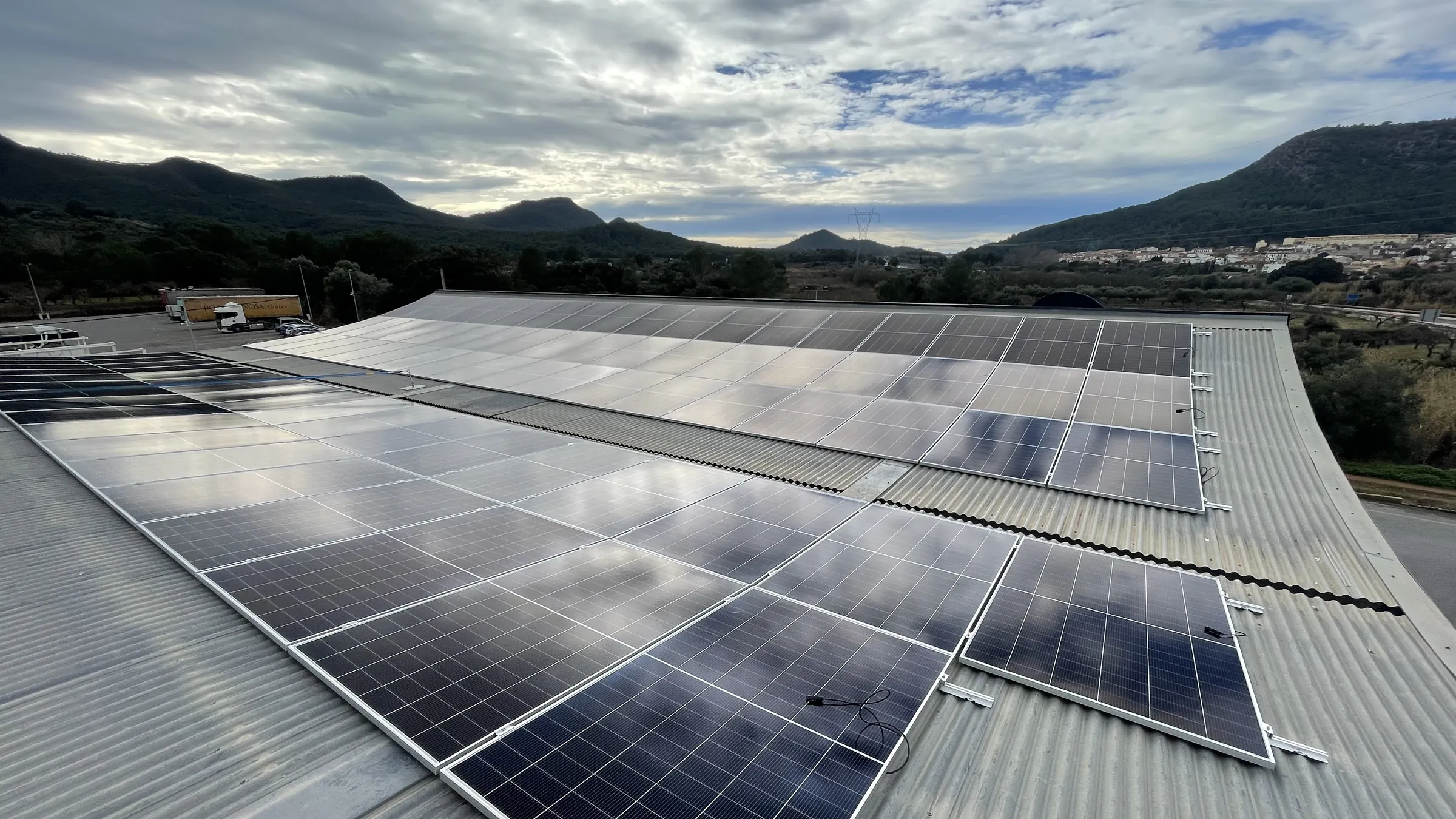 Instalación fotovoltaica de Fritts sobre cubierta de nave industrial con la sierra al fondo