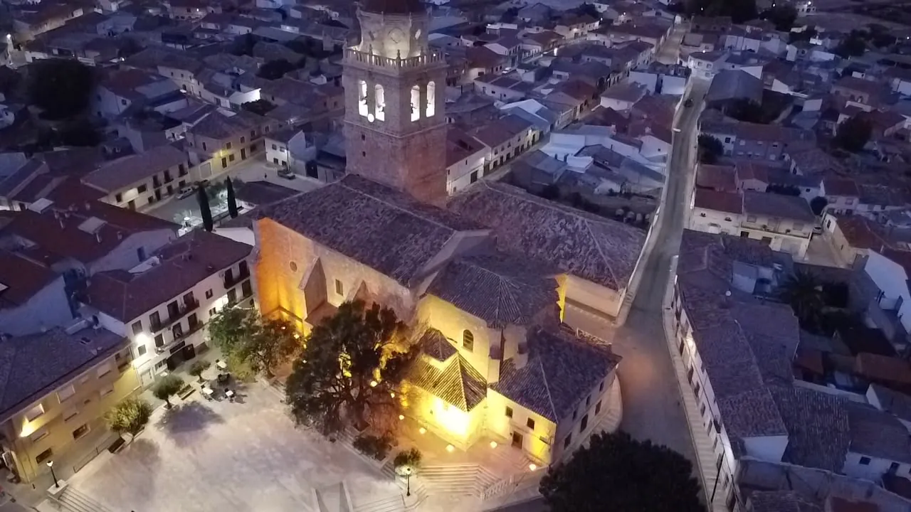 Iglesia y plaza iluminadas de noche, vista aérea