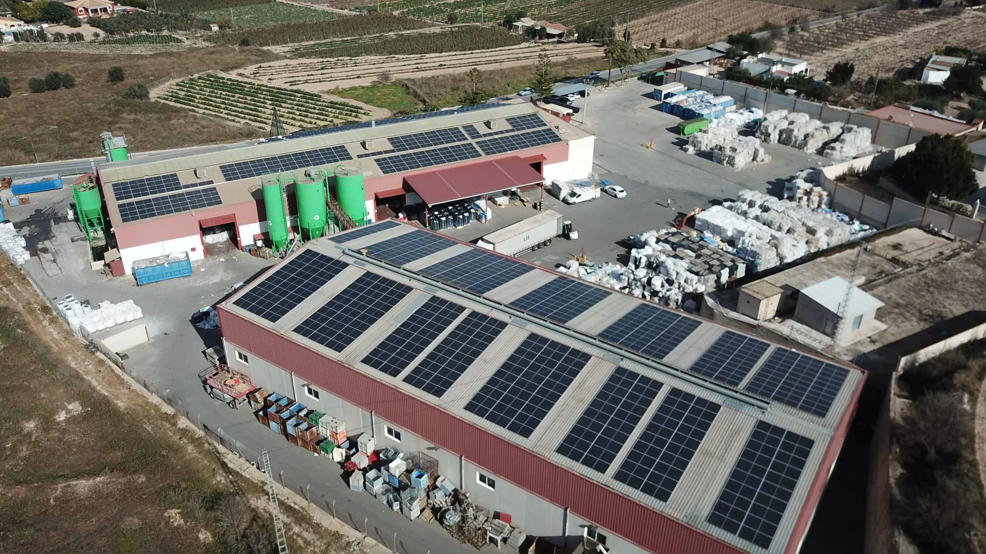 Vista aérea de dos naves industriales con instalación fotovoltaica de autoconsumo en cubierta